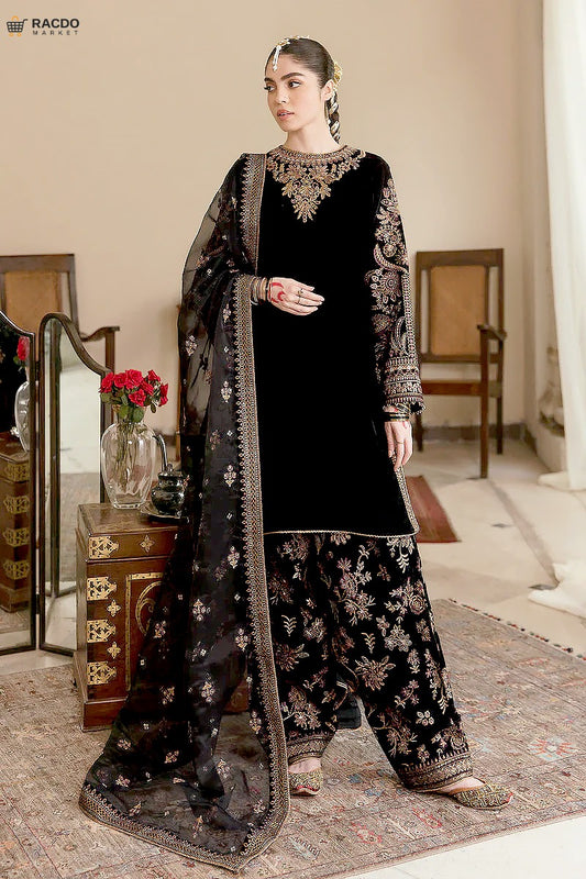 Woman in black embroidered traditional outfit with dupatta in a room setting

