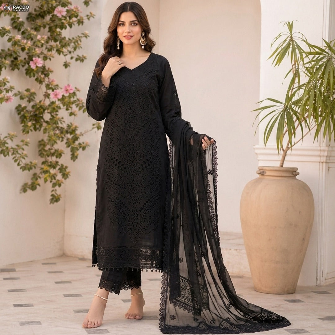 Woman in a black lace outfit standing in a decorated room with plants.

