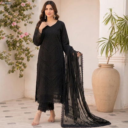 Woman in a black lace outfit standing in a decorated room with plants.

