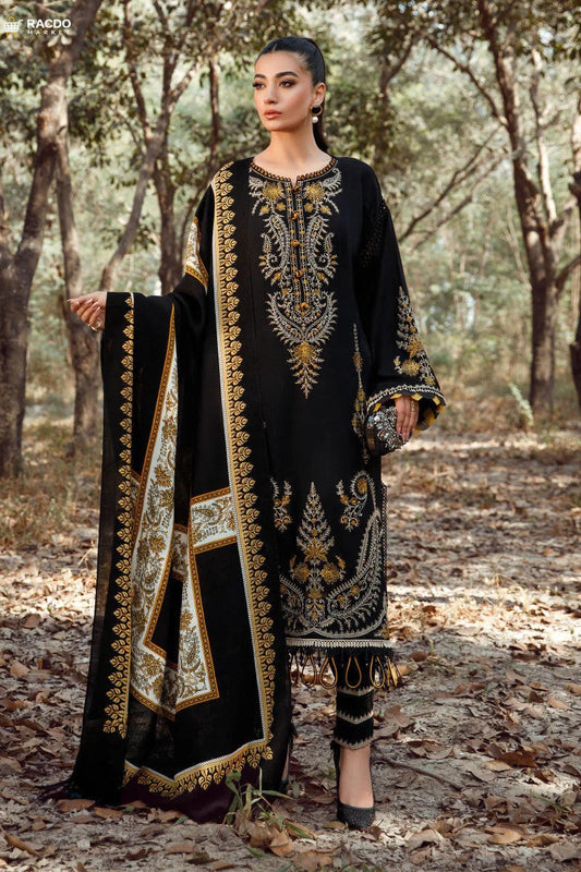 Woman in black embroidered traditional outfit standing in a forest setting

