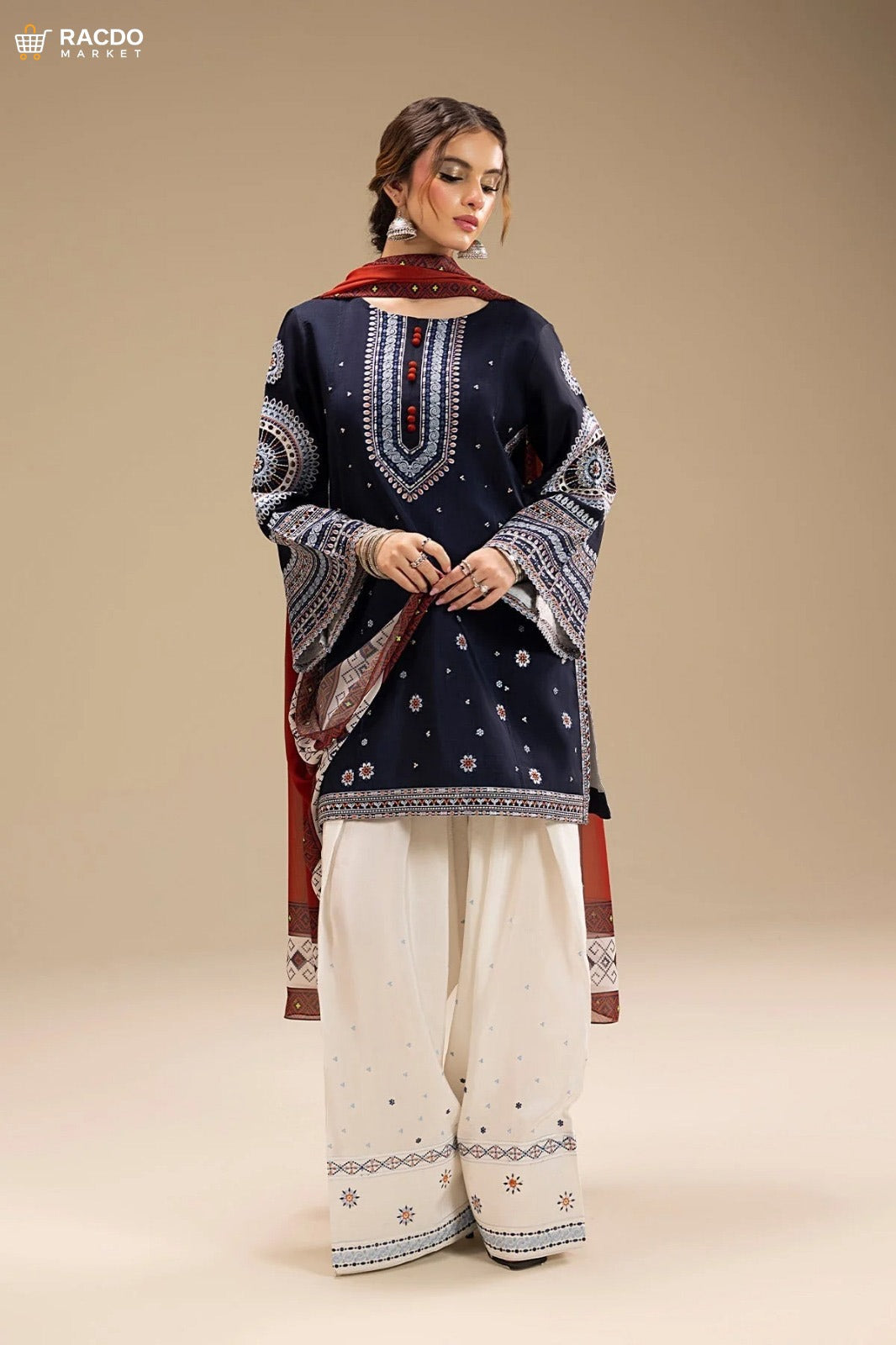 Woman wearing a navy blue embroidered top and white pants with a red dupatta on a beige background

 