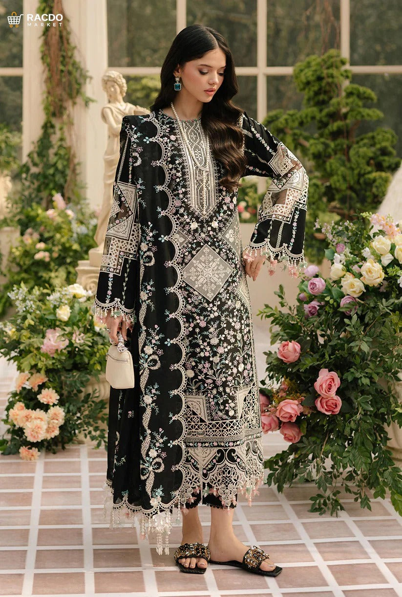 Woman in an elegant black and white embroidered dress standing in a decorative setting with flowers and statues.


