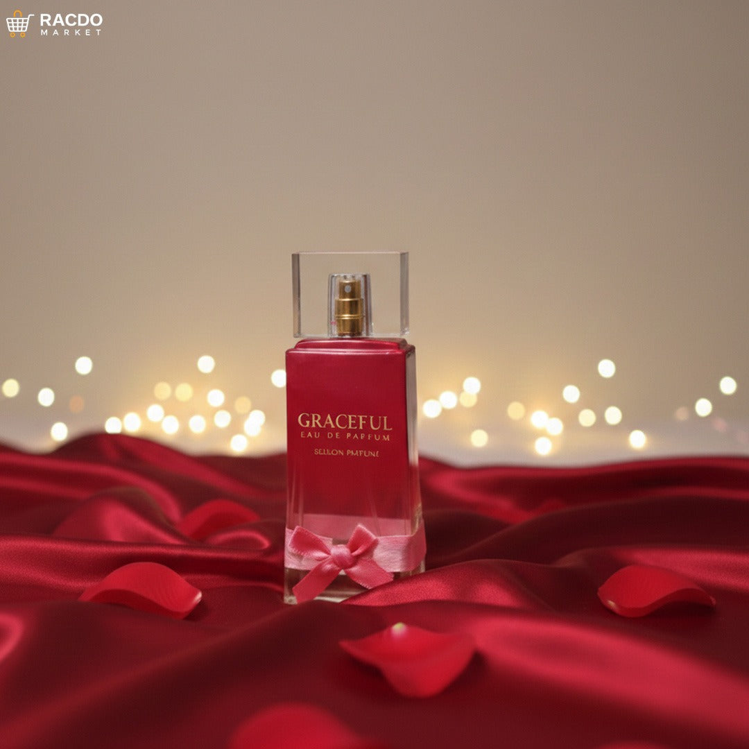 Red perfume bottle with a bow on a red fabric background with blurred lights