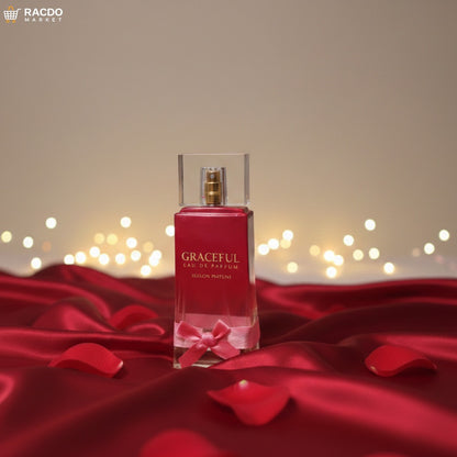 Red perfume bottle with a bow on a red fabric background with blurred lights