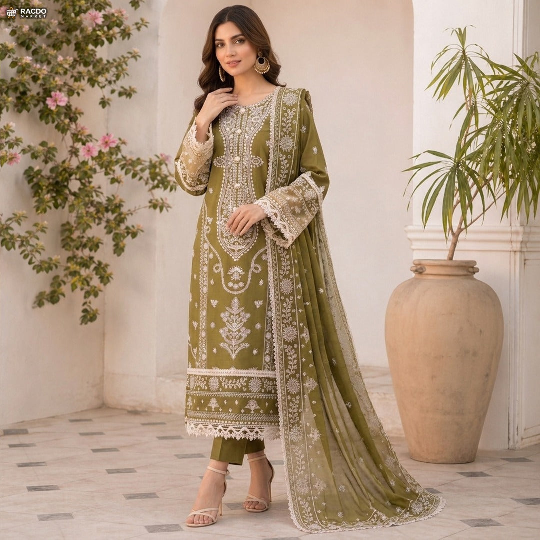 Woman in a green embroidered traditional outfit standing in a decorated room with plants.

