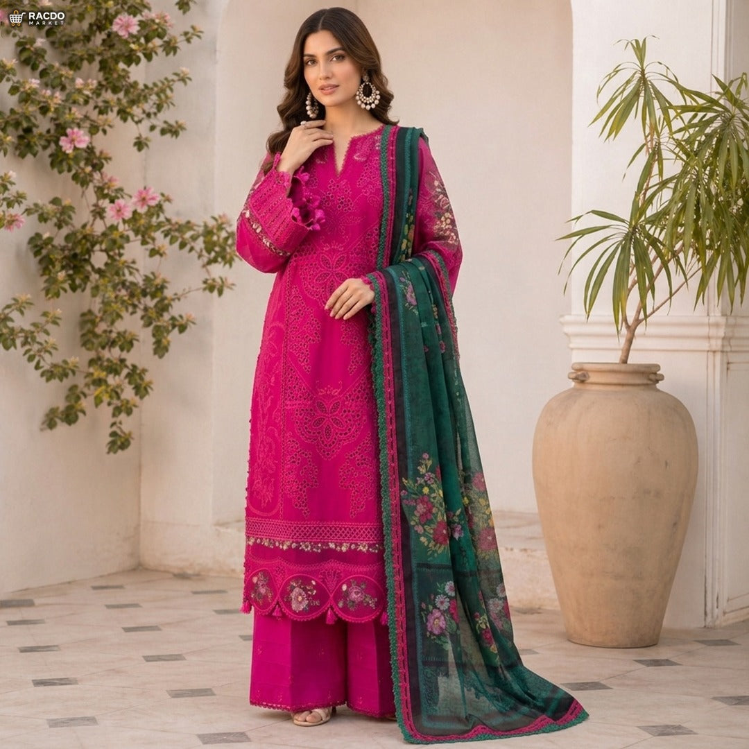 Woman in a pink embroidered outfit with a green dupatta standing indoors with plants in the background

