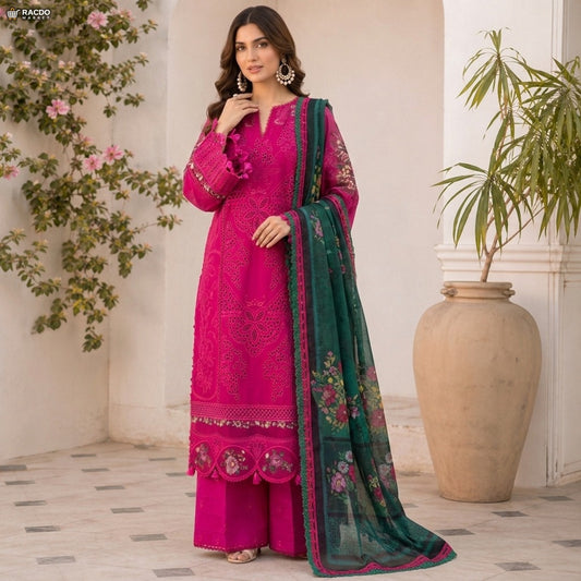 Woman in a pink embroidered outfit with a green dupatta standing indoors with plants in the background

