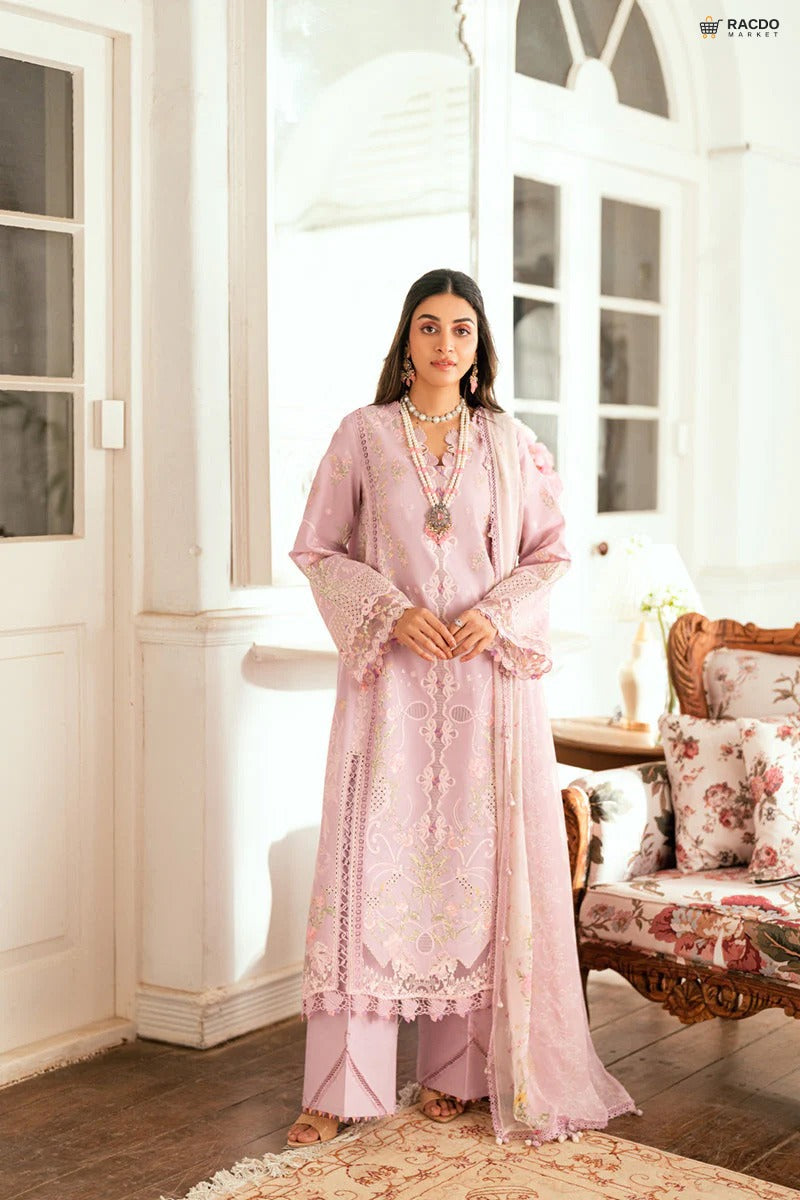 Woman in a pink traditional outfit standing in a well-lit room with white walls and wooden floor.

