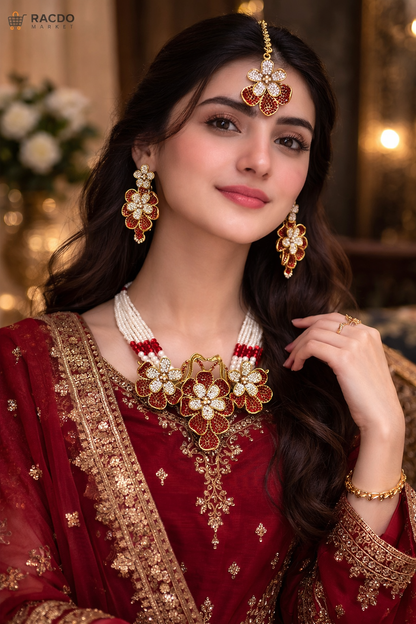 Woman wearing traditional red and gold attire with jewelry, posing indoors.