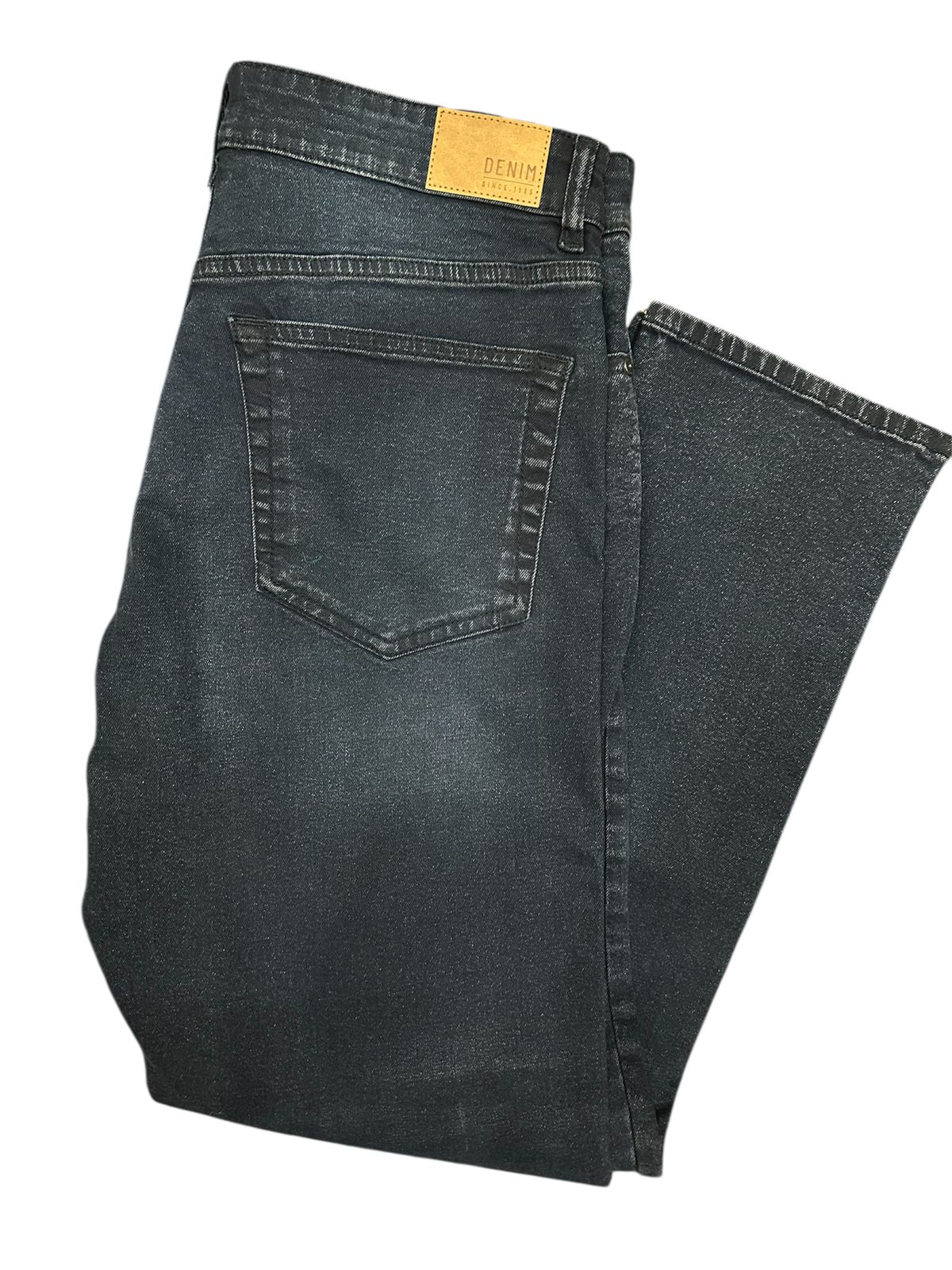 Folded pair of black jeans on a white background

