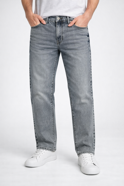 Person wearing gray jeans and white sneakers on a white background

