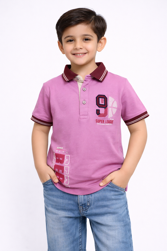 Child wearing a pink polo shirt with a design and text, standing against a white background

