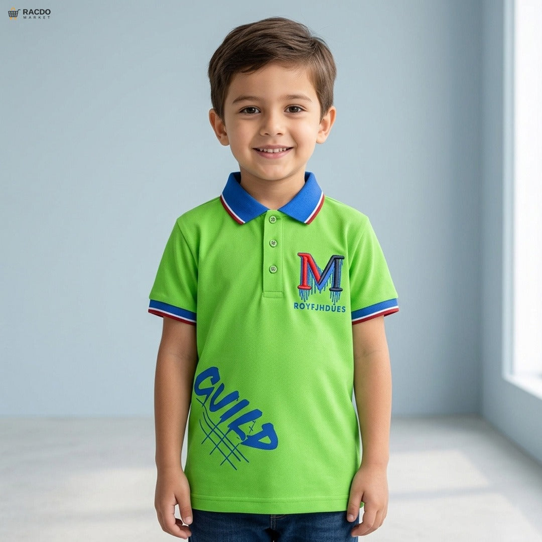 Child wearing a green polo shirt with a logo and text, standing against a light blue wall.

