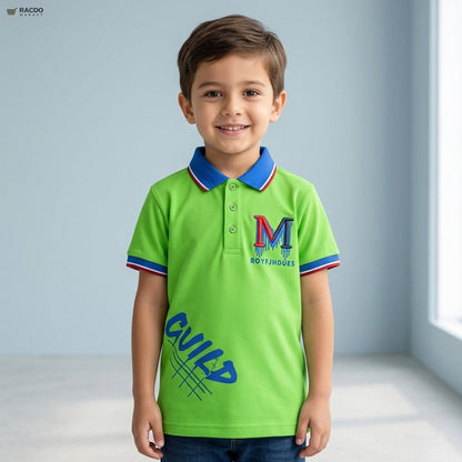 Child wearing a green polo shirt with a logo and text, standing against a light blue wall.

