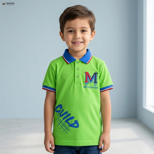 Child wearing a green polo shirt with a logo and text, standing against a light blue wall.

