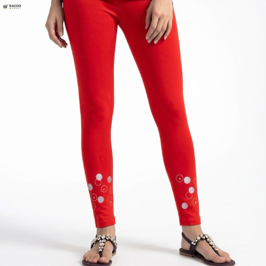 Red leggings with white circular patterns worn by a person on a white background

