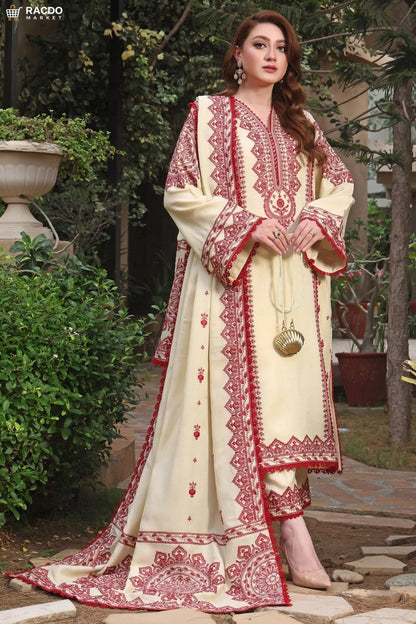 Woman wearing a cream and red embroidered traditional outfit in an outdoor setting.

