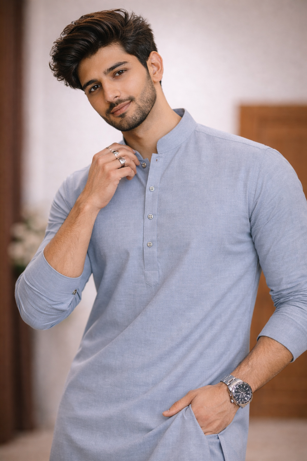 Man wearing a light blue kurta with a blurred background

