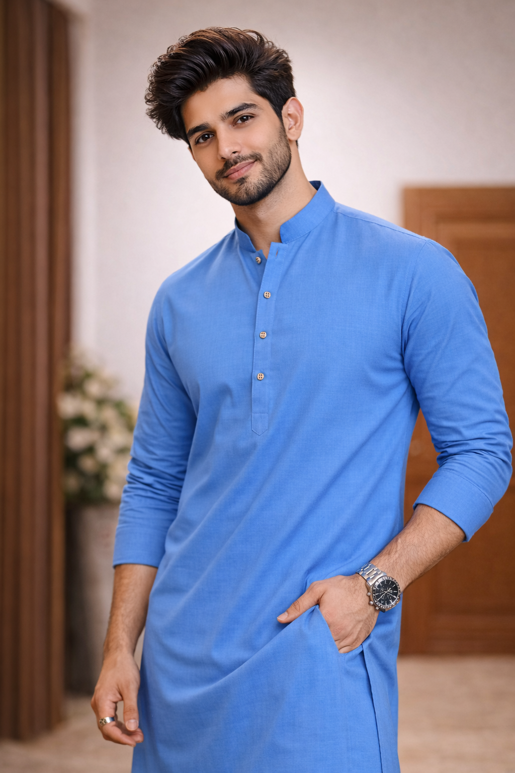 Man wearing a blue kurta with a neutral background

